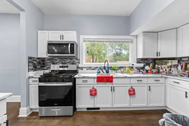 a kitchen with a stove a sink and a microwave