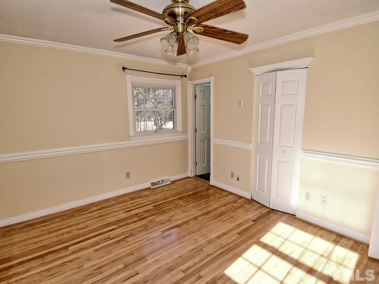 5708 Hayloft Circle Raleigh, NC 27606 - Photo 14 of 27 a view of an empty room with wooden floor and a window