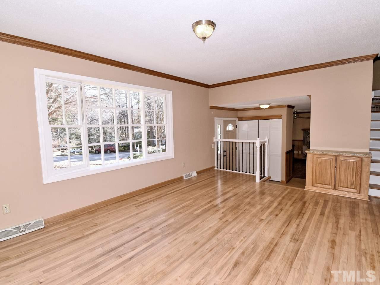5708 Hayloft Circle Raleigh, NC 27606 - Photo 3 of 27 a view of an empty room with wooden floor and a window