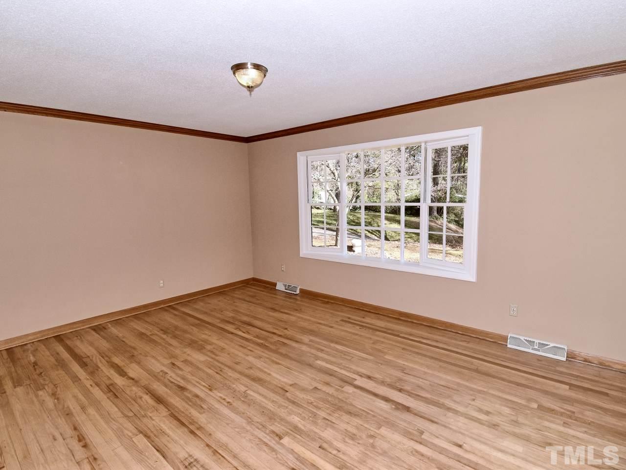 5708 Hayloft Circle Raleigh, NC 27606 - Photo 5 of 27 a view of an empty room with wooden floor and a window
