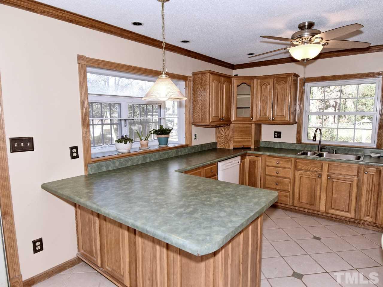 5708 Hayloft Circle Raleigh, NC 27606 - Photo 7 of 27 a kitchen with kitchen island granite countertop a sink cabinets and window