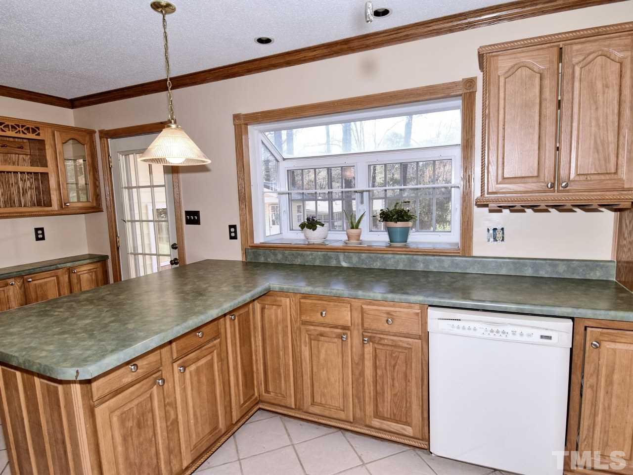 5708 Hayloft Circle Raleigh, NC 27606 - Photo 9 of 27 a kitchen with granite countertop a sink and white cabinets