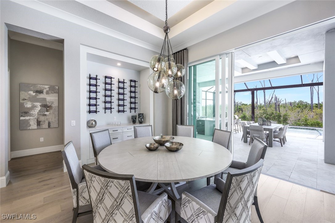 8903 Nevis Way Naples, FL 34112 - Photo 7 of 36 a view of a dining room with furniture window and wooden floor