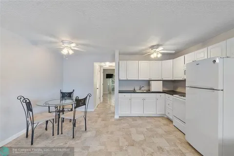 a kitchen with cabinets appliances a sink and a potted plant