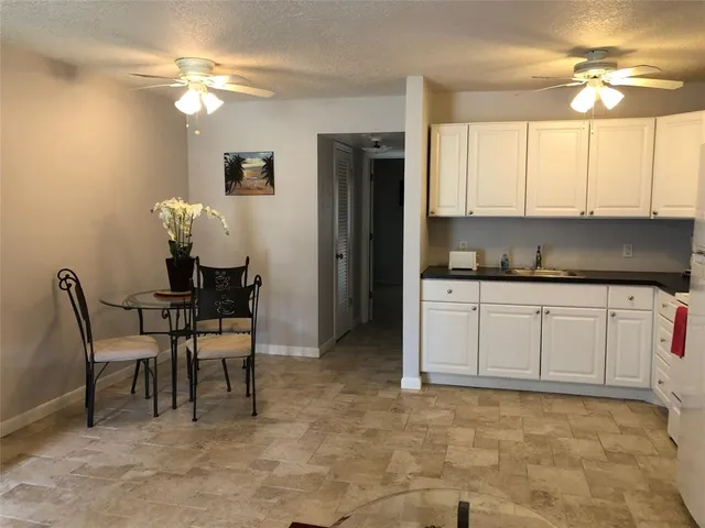 a kitchen with cabinets and chairs
