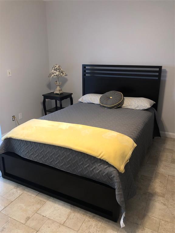 518 Durham, Unit 518 Deerfield Beach, FL 33442 - Photo 10 of 31 a bedroom with a bed and a lamp