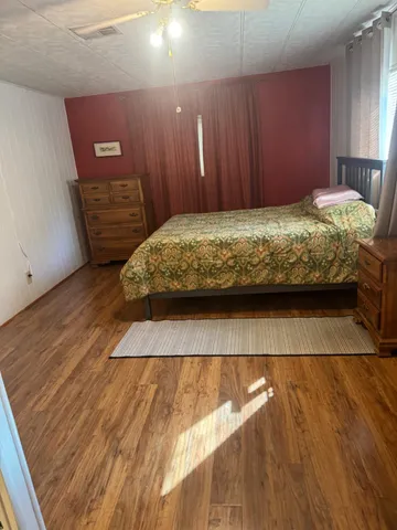 a view of a bedroom with wooden floor