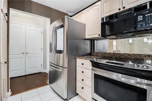 a kitchen with stainless steel appliances granite countertop a refrigerator and a stove top oven