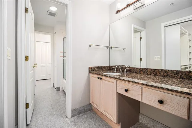 a bathroom with a granite countertop sink and a mirror