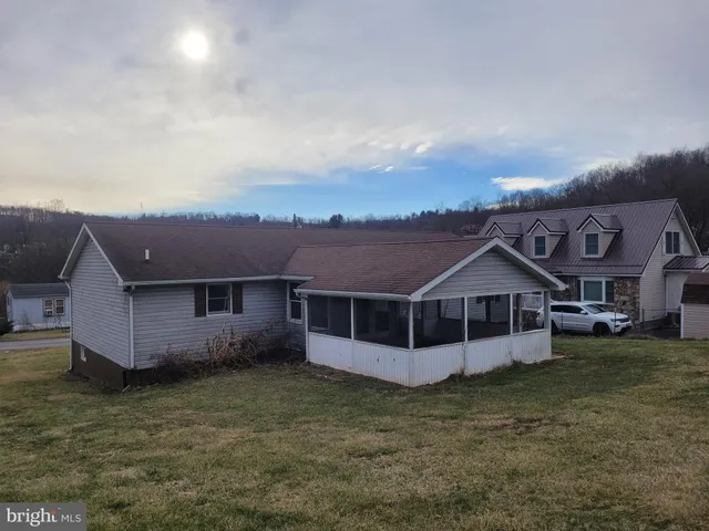 an aerial view of a house with a yard and large trees