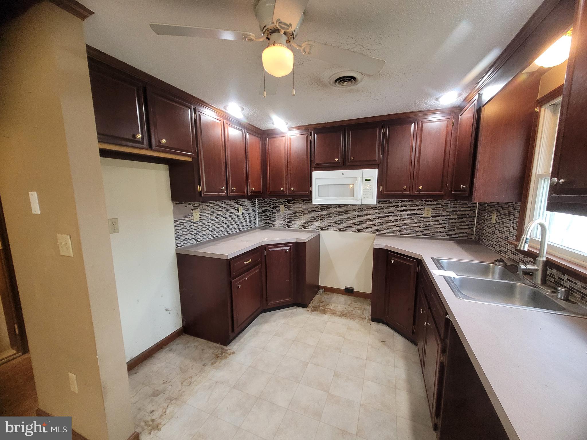 16821 Porter Road Northwest Frostburg, MD 21532 - Photo 8 of 39 a kitchen with a refrigerator sink and wooden cabinets