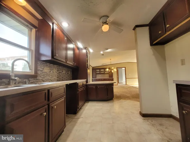 a large kitchen with kitchen island a sink stainless steel appliances and cabinets
