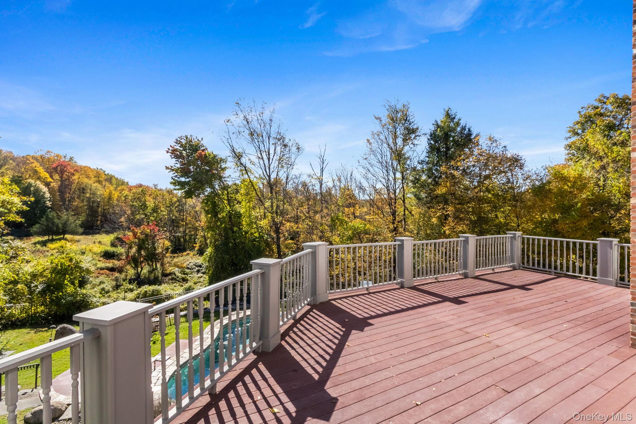 496 Long Ridge Road Bedford, NY 10576 - Photo 18 of 49 Wooden deck with an outdoor pool below