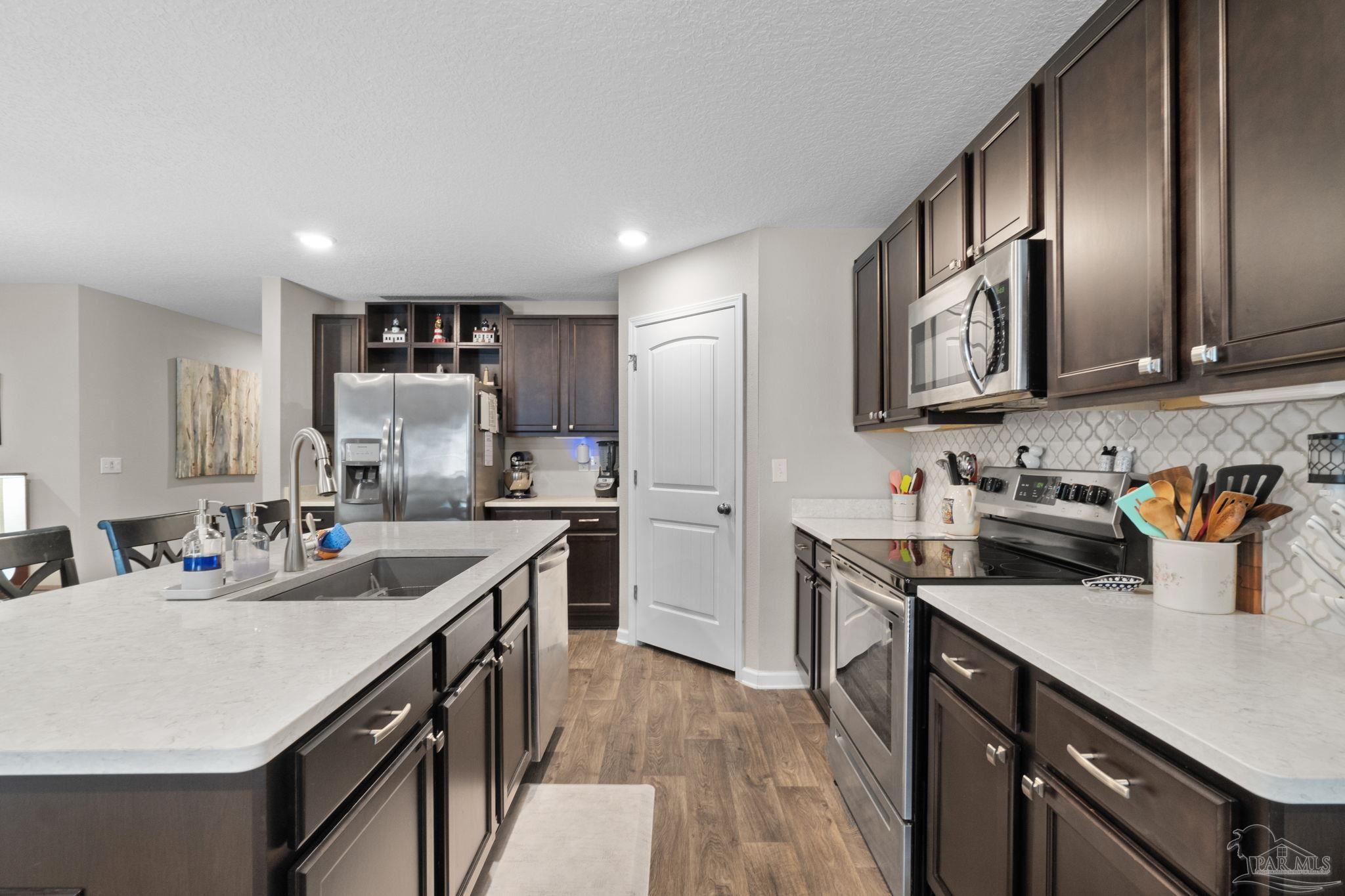 4082 Chickadee Street Milton, FL 32583 - Photo 11 of 43 a kitchen with a sink stove and cabinets