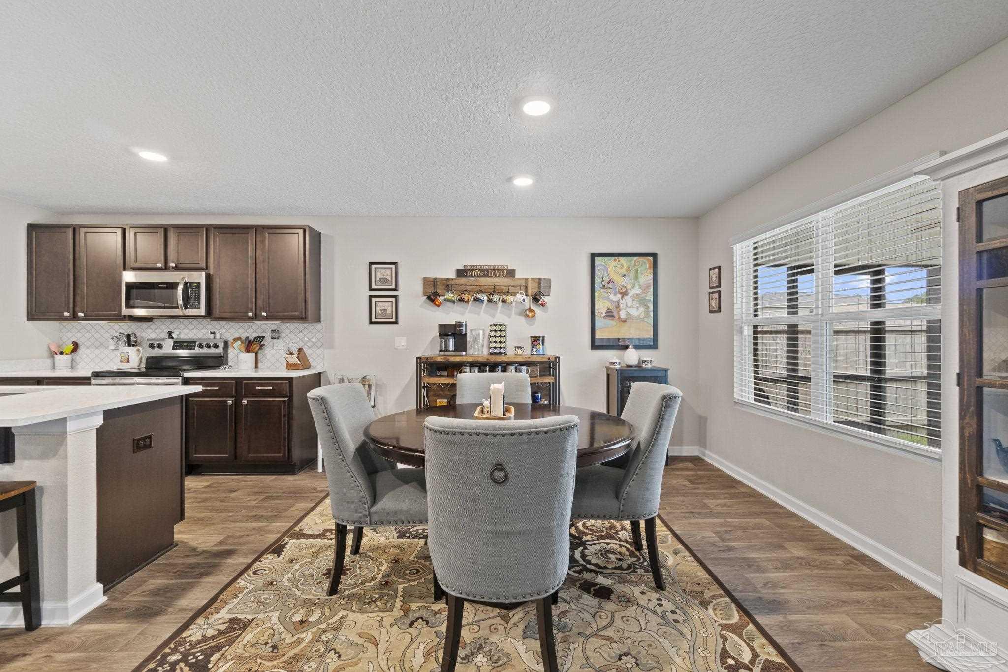 4082 Chickadee Street Milton, FL 32583 - Photo 14 of 43 a view of a dining room with furniture a rug and wooden floor