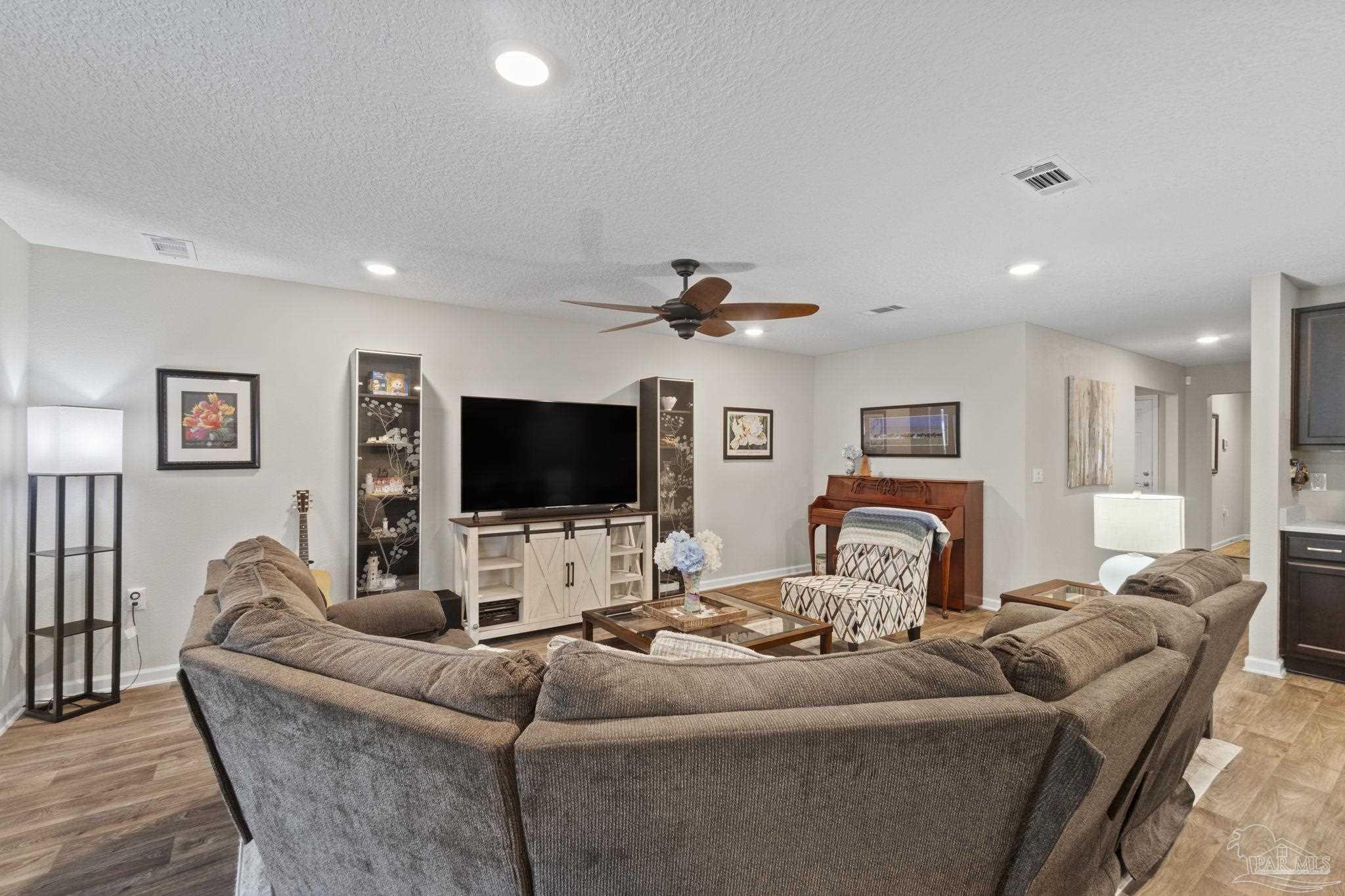 4082 Chickadee Street Milton, FL 32583 - Photo 16 of 43 a living room with furniture and a flat screen tv