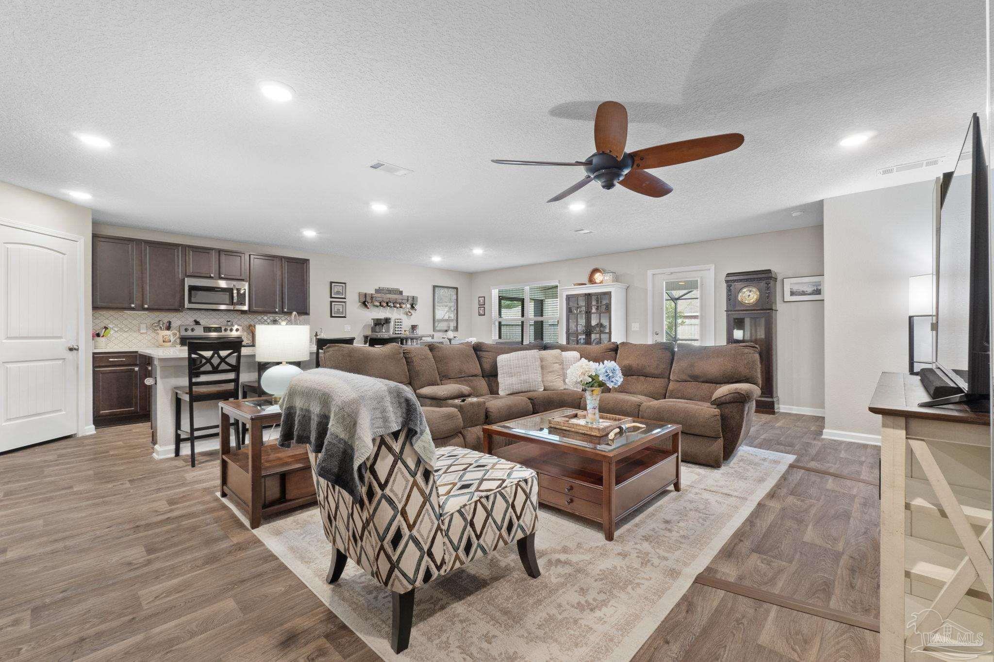 4082 Chickadee Street Milton, FL 32583 - Photo 17 of 43 a living room with lots of furniture and a view of kitchen