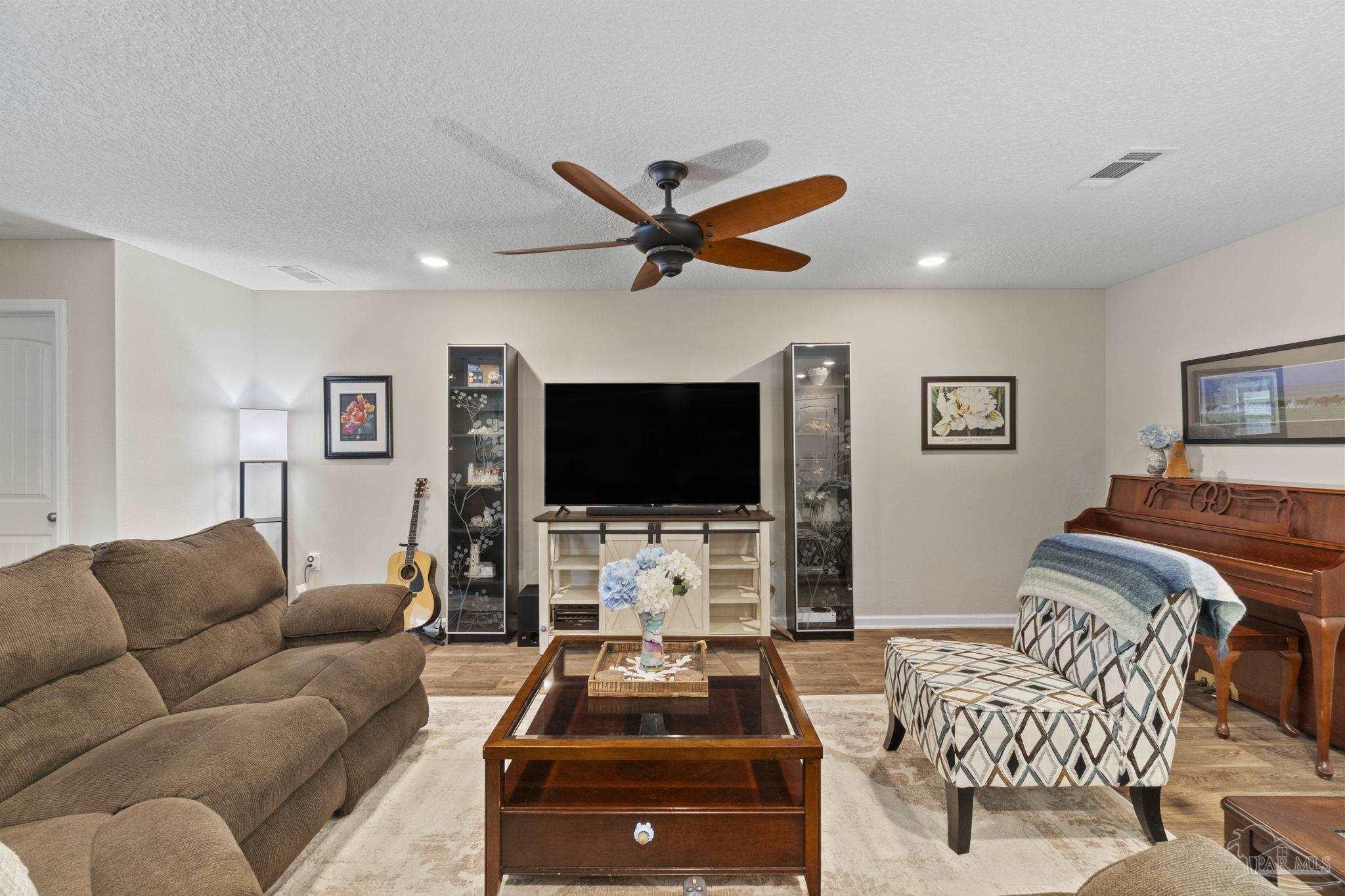 4082 Chickadee Street Milton, FL 32583 - Photo 19 of 43 a living room with furniture and a flat screen tv