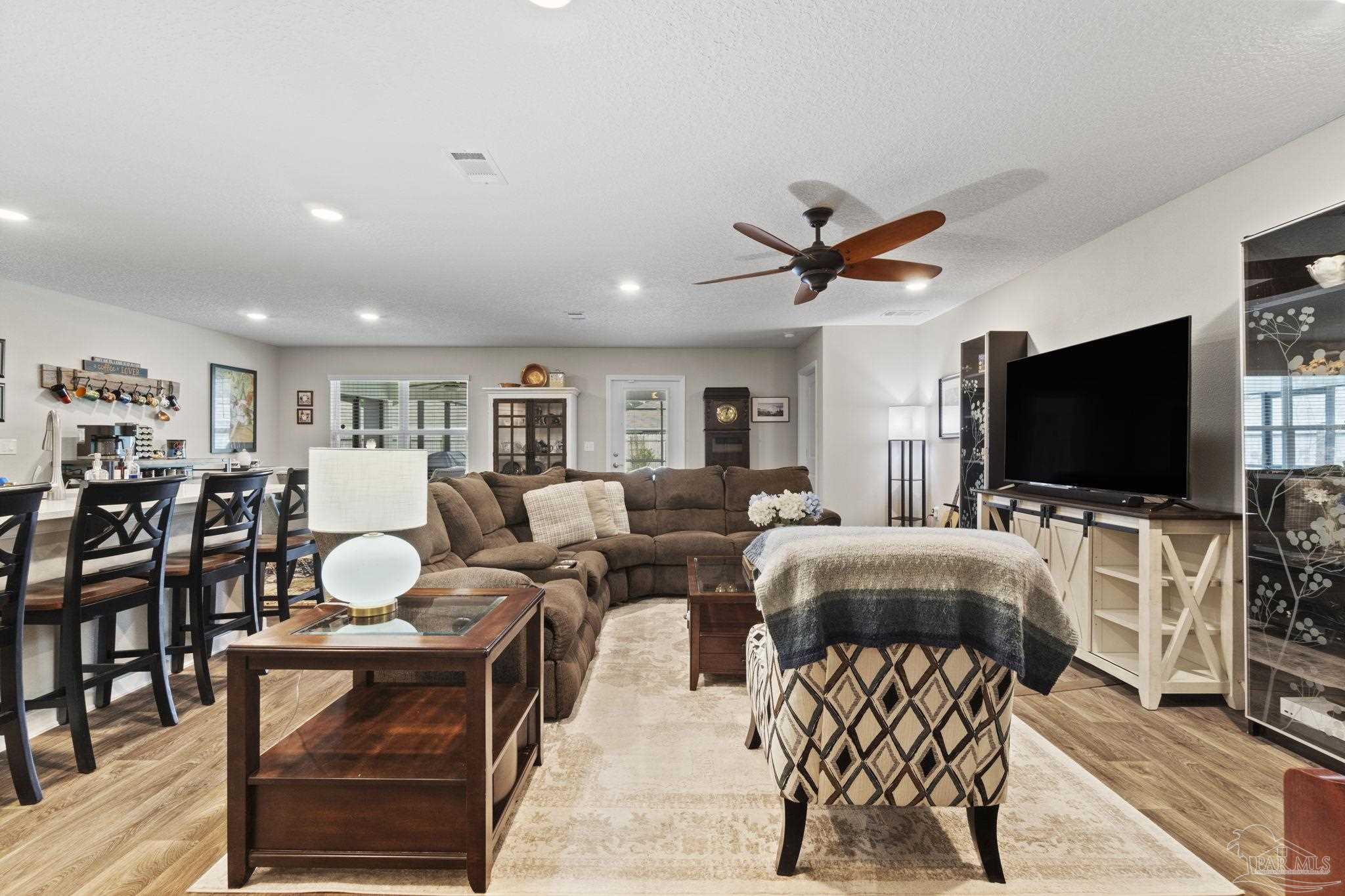 4082 Chickadee Street Milton, FL 32583 - Photo 20 of 43 a living room with furniture kitchen view and a flat screen tv