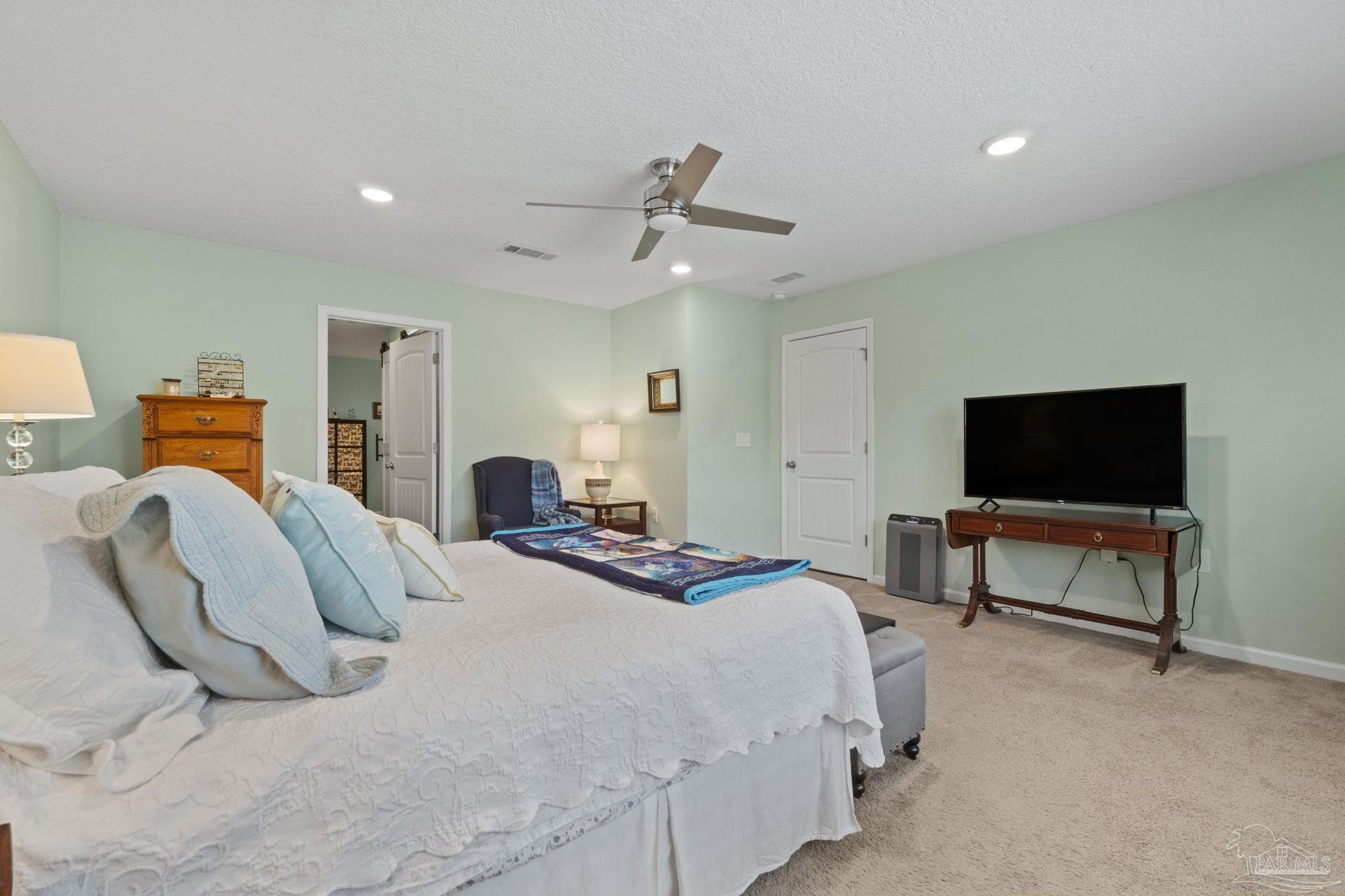 4082 Chickadee Street Milton, FL 32583 - Photo 24 of 43 a bedroom with a bed and a flat screen tv