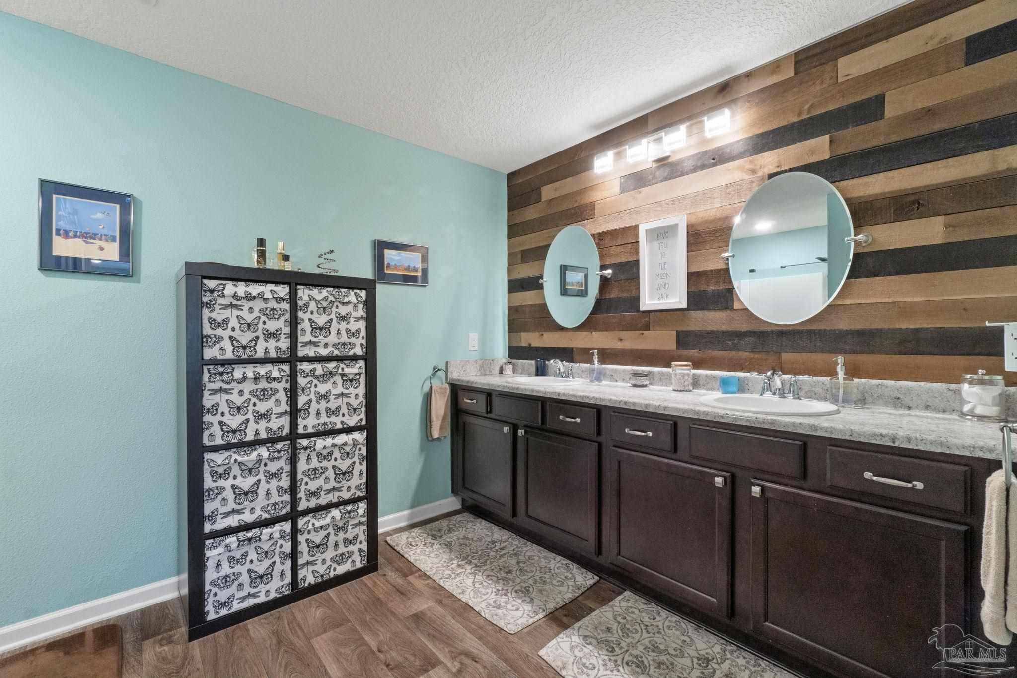 4082 Chickadee Street Milton, FL 32583 - Photo 26 of 43 a bathroom with a sink and a large mirror