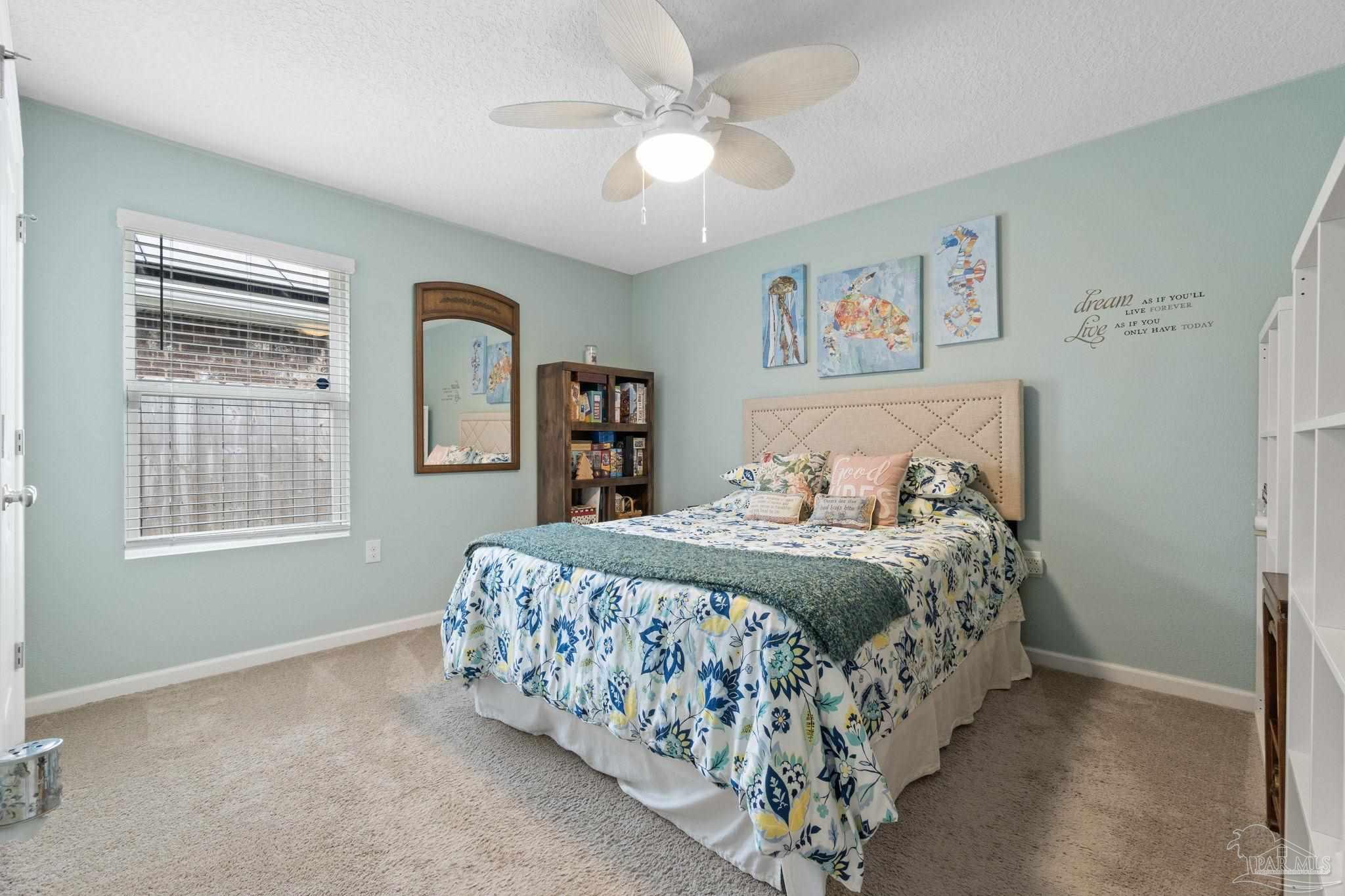 4082 Chickadee Street Milton, FL 32583 - Photo 31 of 43 a bedroom with a bed and a chandelier