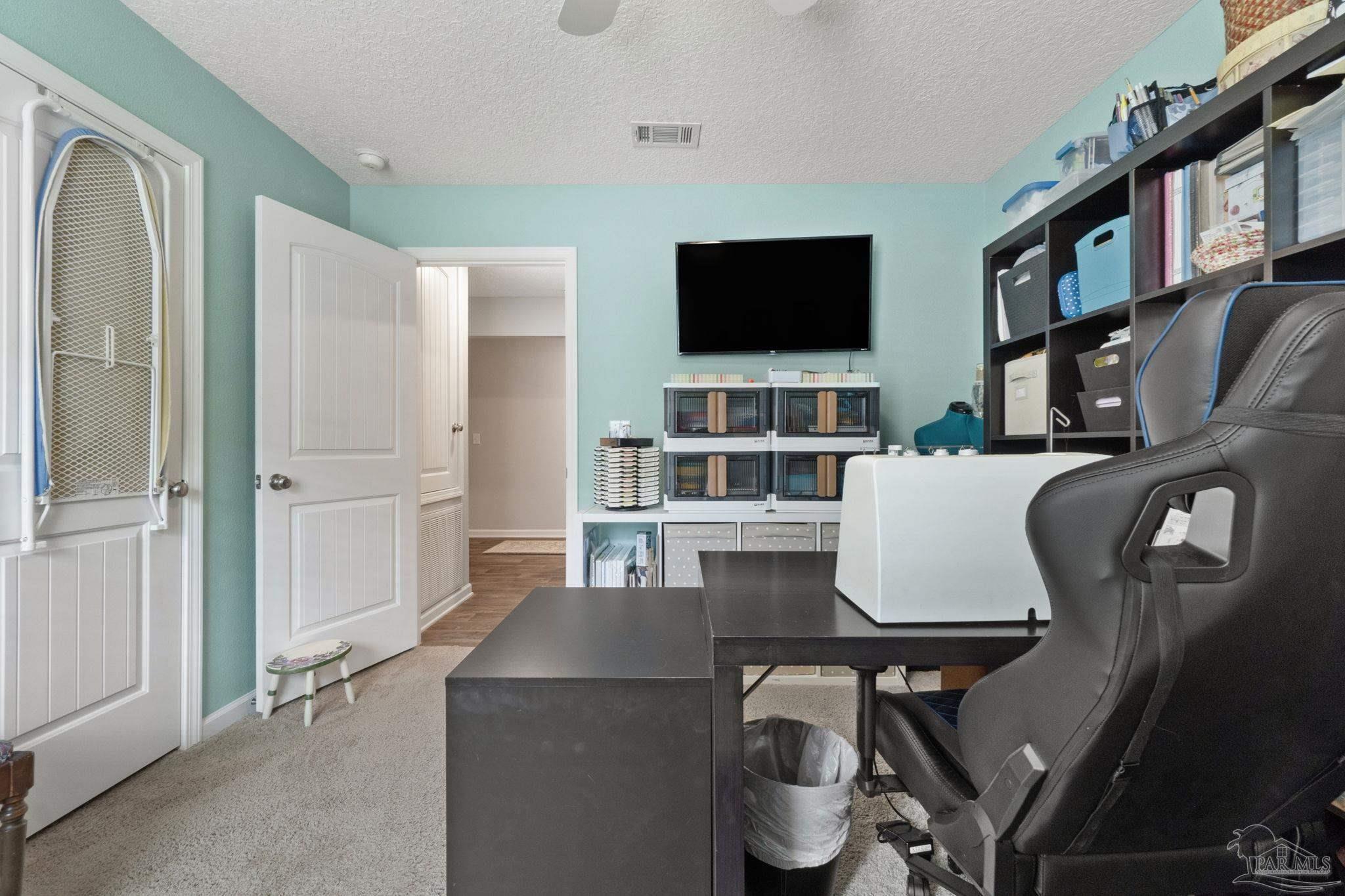 4082 Chickadee Street Milton, FL 32583 - Photo 34 of 43 a living room with furniture a flat screen tv and kitchen view