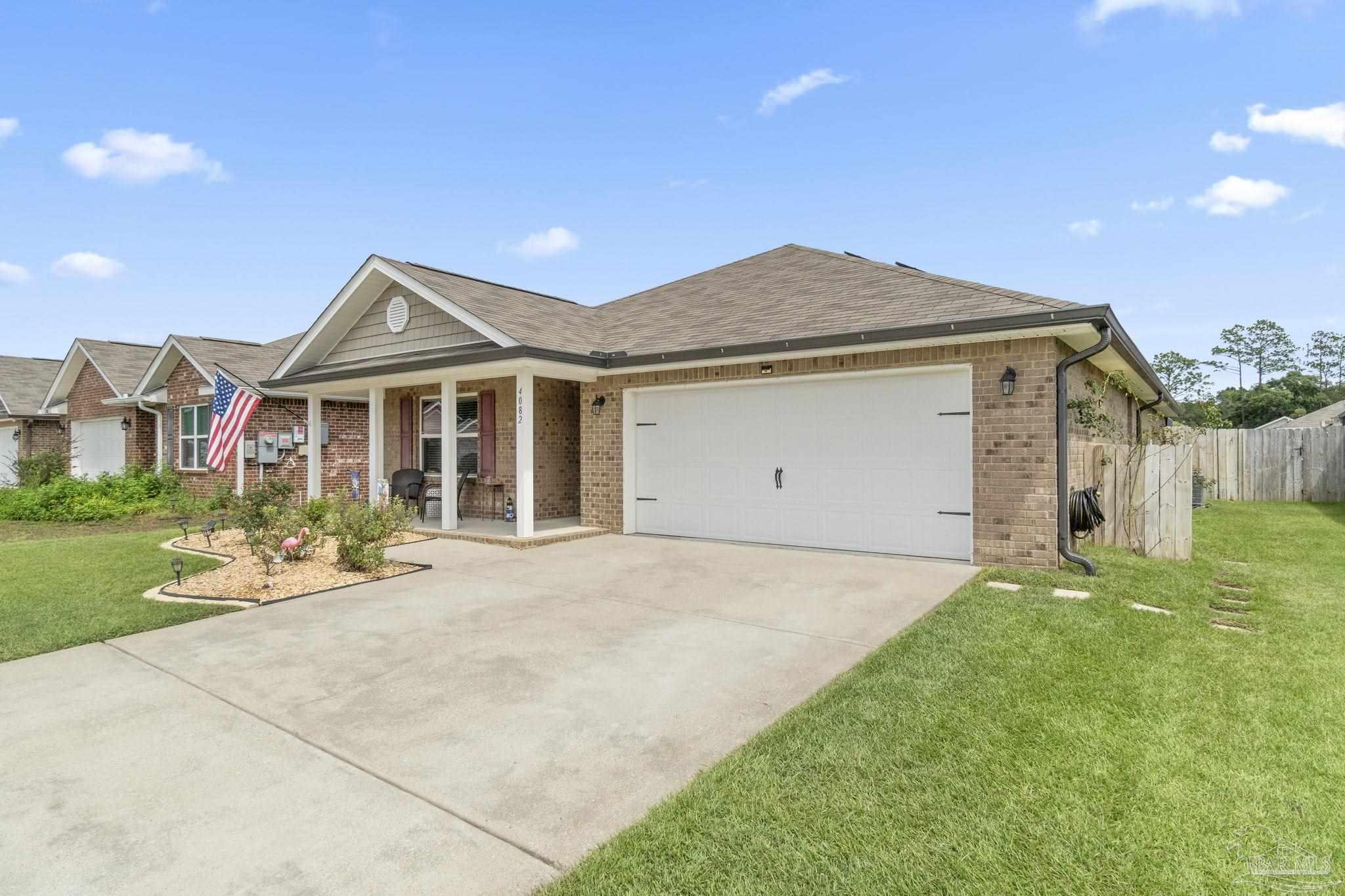 4082 Chickadee Street Milton, FL 32583 - Photo 4 of 43 a front view of a house with a yard and garage