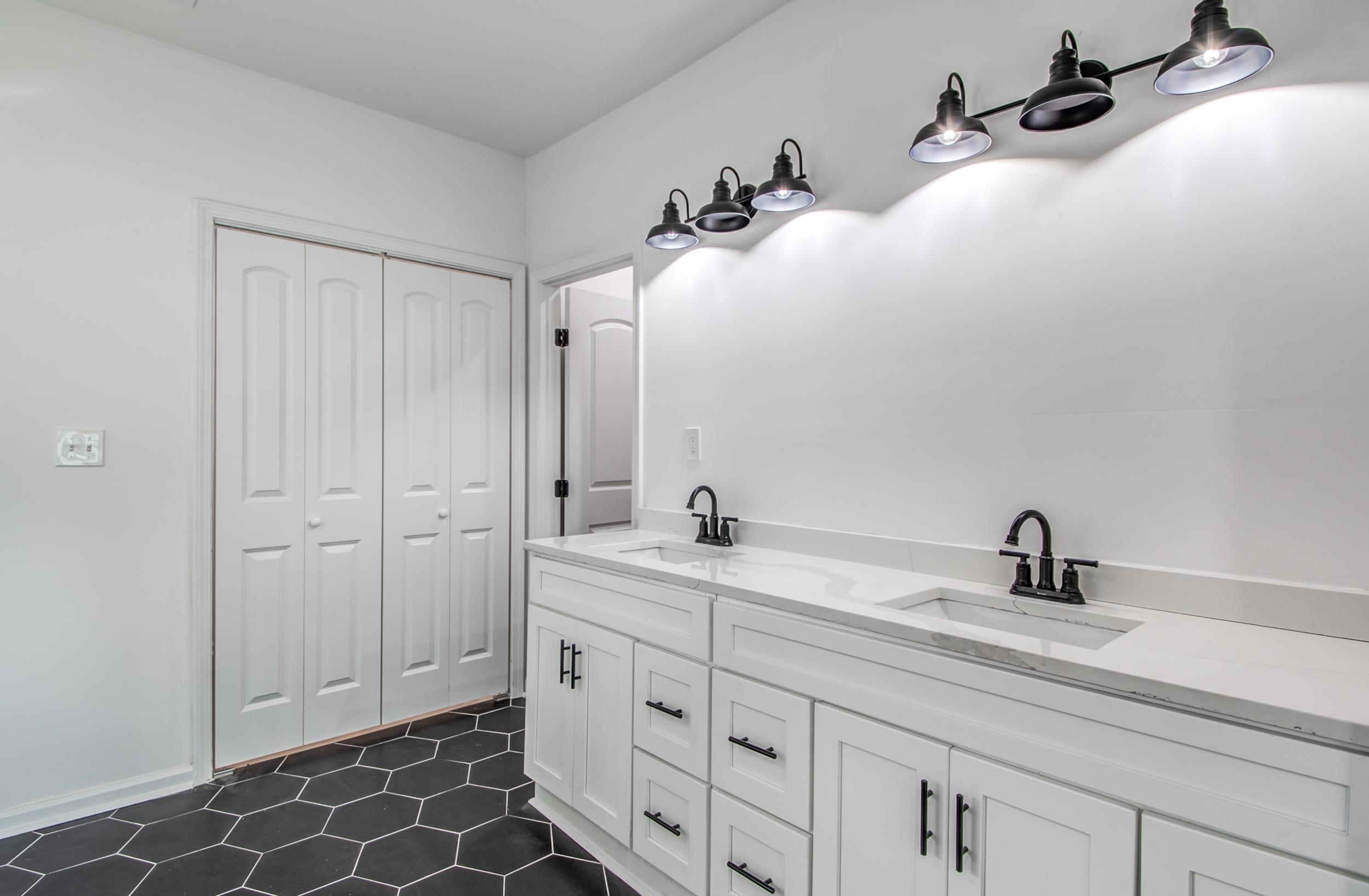 1781 Forest Avenue Memphis, TN 38112 - Photo 25 of 30 Bathroom with a closet, double vanity, and dark tile patterned flooring