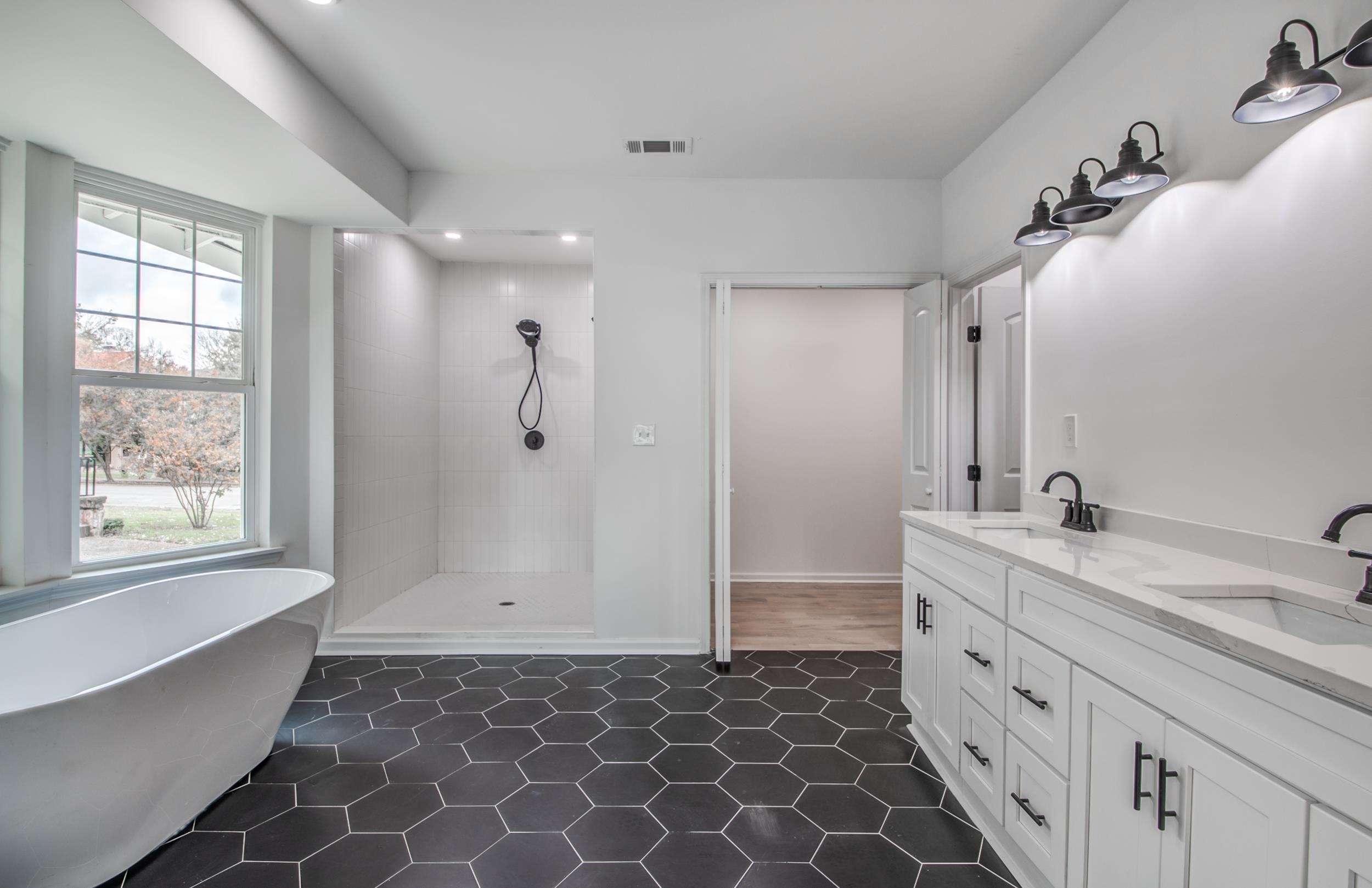 1781 Forest Avenue Memphis, TN 38112 - Photo 26 of 30 Bathroom featuring double vanity, a freestanding tub, a tile shower, dark tile patterned floors, and recessed lighting