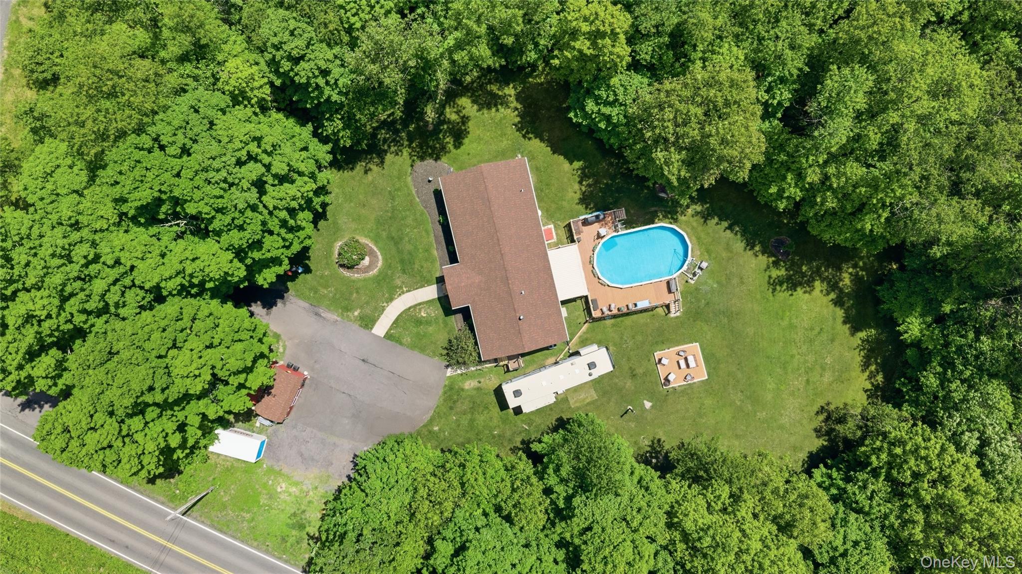 239-241 Fosler Road Highland, NY 12528 - Photo 3 of 42 Expansive property featuring a central residence with a brown shingle roof, an oval above-ground pool with surrounding wood decking, and a large grassy yard