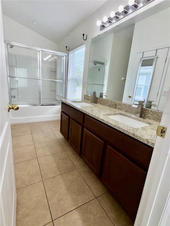 6404 South Goldenrod Road, Unit 2A Orlando, FL 32822 - Photo 25 of 40 a spacious bathroom with a granite countertop sink a mirror and a bathtub