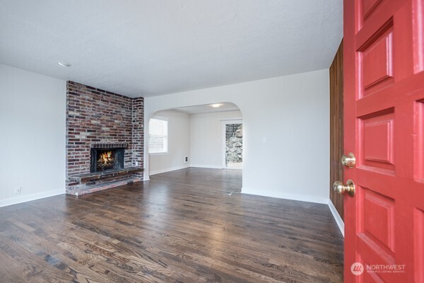 1809 5th Avenue North Seattle, WA 98109 - Photo 16 of 25 a view of an empty room with wooden floor fireplace and a window