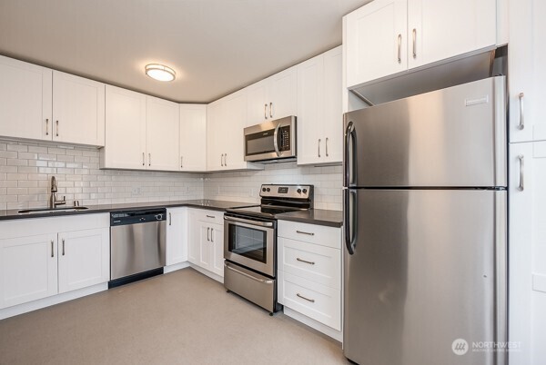 1809 5th Avenue North Seattle, WA 98109 - Photo 19 of 25 a kitchen with stainless steel appliances granite countertop a refrigerator a stove a sink and a microwave