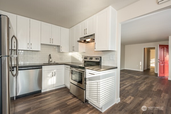 1809 5th Avenue North Seattle, WA 98109 - Photo 20 of 25 a kitchen with granite countertop white cabinets and white appliances