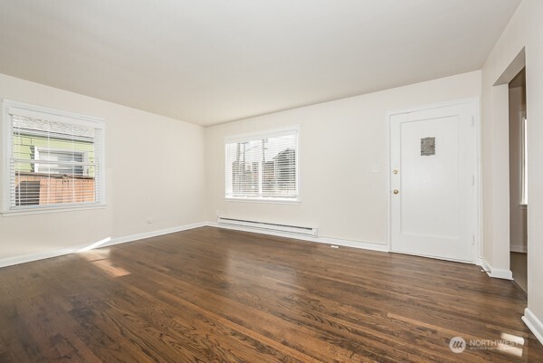 1809 5th Avenue North Seattle, WA 98109 - Photo 21 of 25 a view of an empty room with wooden floor and a window