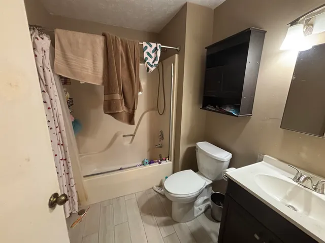 a view of a house with a car parked in a forest