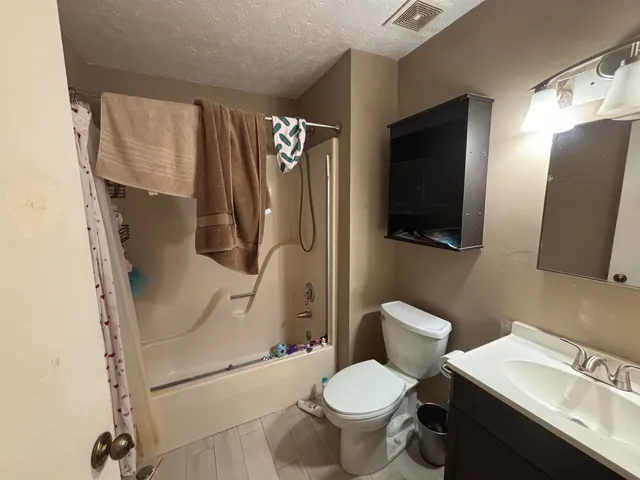 a white toilet sitting next to a bathroom sink and a mirror