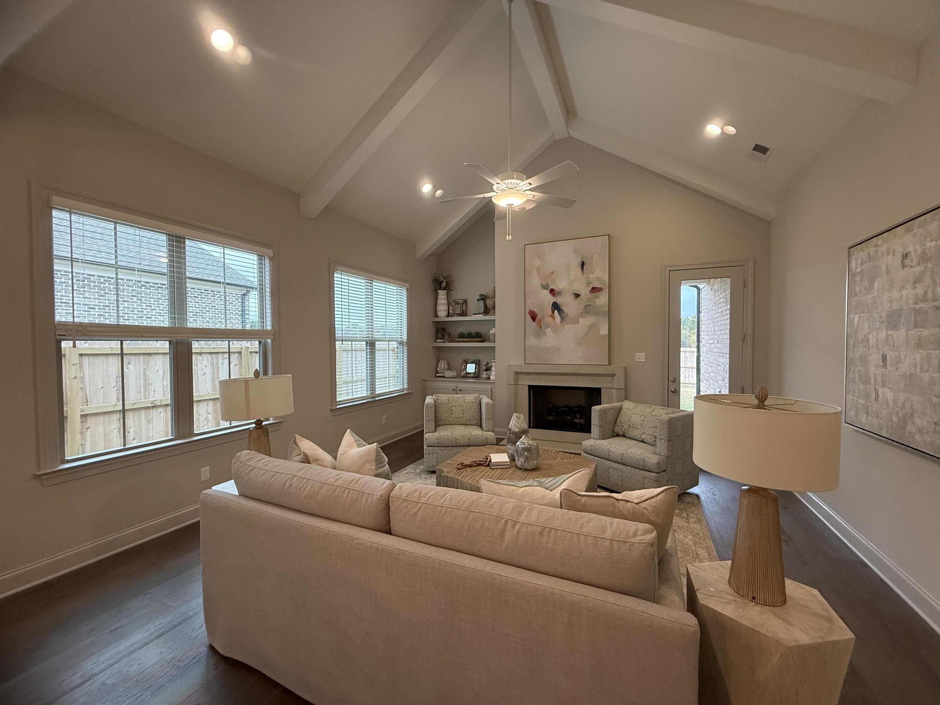 a living room with furniture a fireplace and a large window