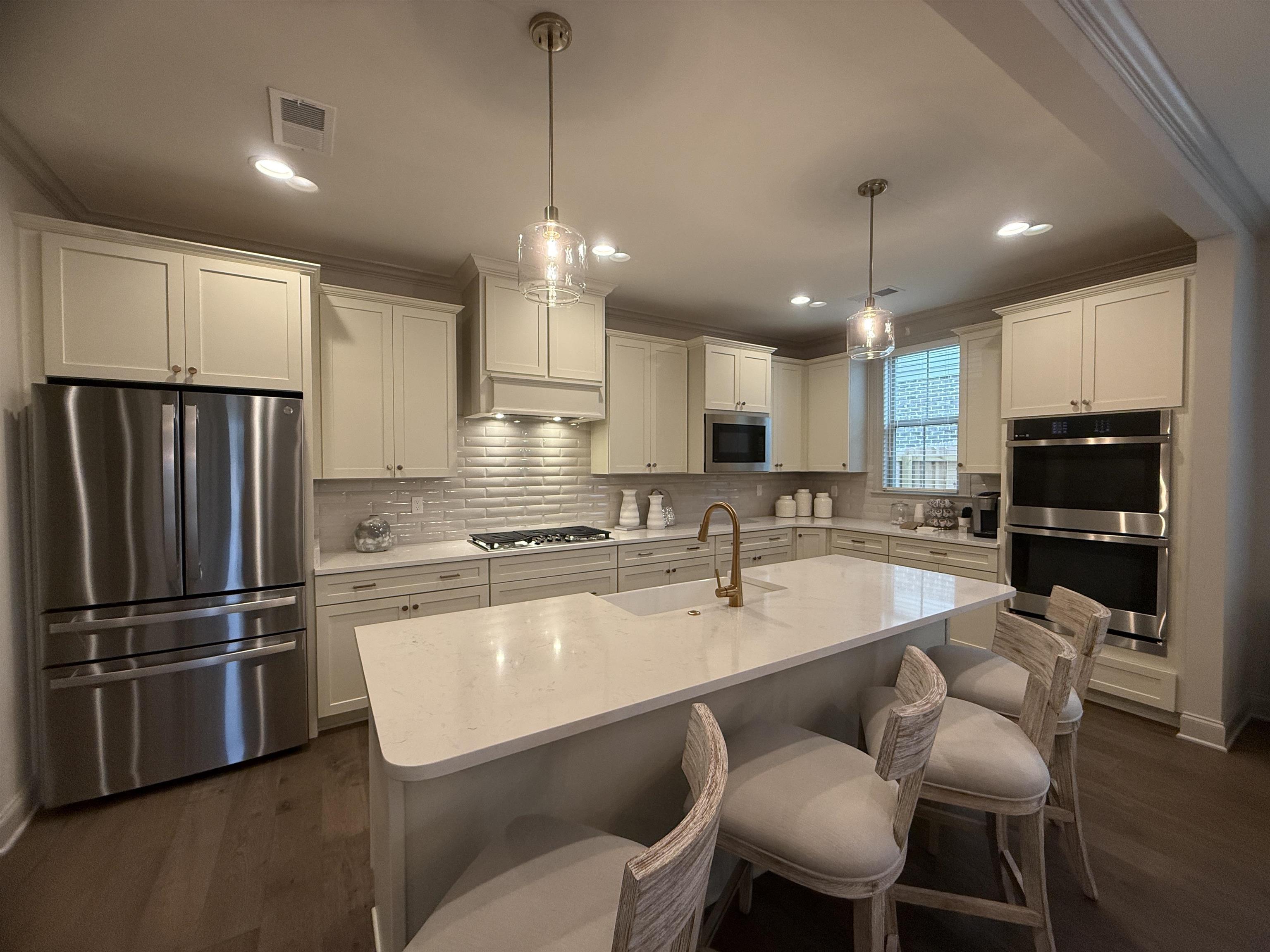 11516 Sunsparkler Way Collierville, TN 38017 - Photo 2 of 24 Kitchen with crown molding, stainless steel appliances, tasteful backsplash, dark wood-style floors, and pendant lighting