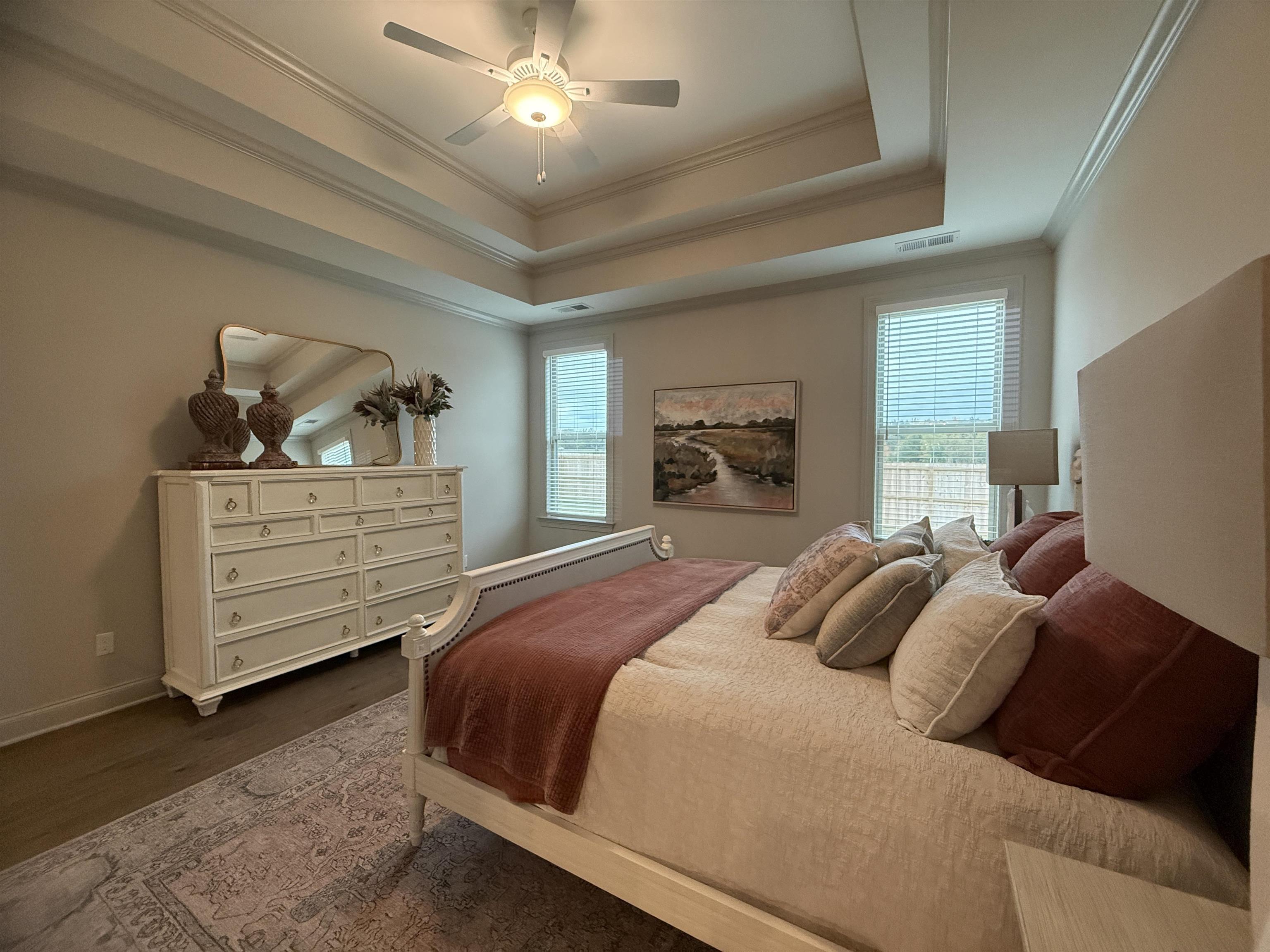 11516 Sunsparkler Way Collierville, TN 38017 - Photo 7 of 24 Bedroom with a tray ceiling, crown molding, dark wood-type flooring, ceiling fan, and multiple windows