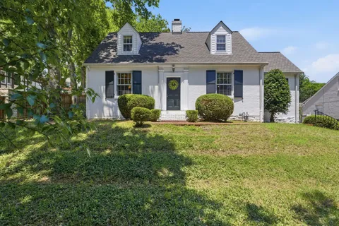 a front view of a house with yard and green space