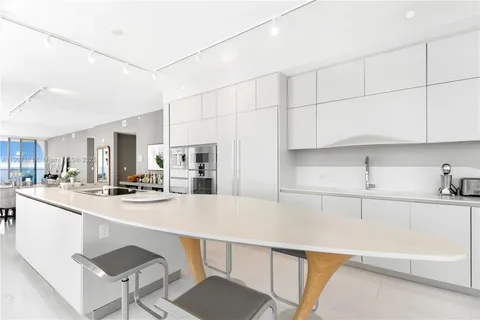 a kitchen with kitchen island a sink table and chairs