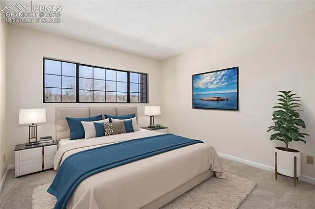 a bedroom with a large bed and a potted plant