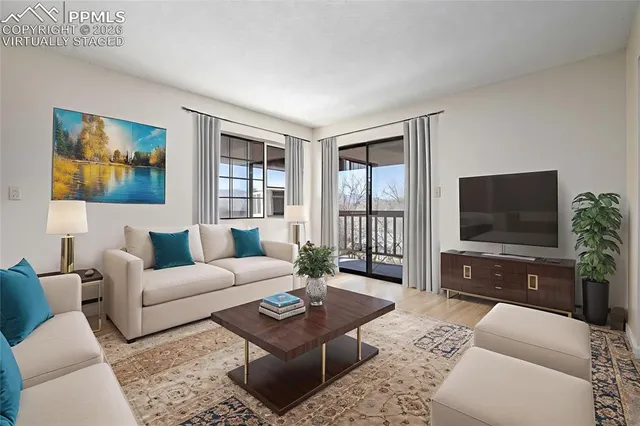 a living room with furniture a flat screen tv and a large window