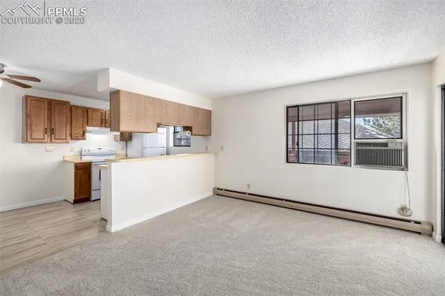 a view of a kitchen with refrigerator and windows