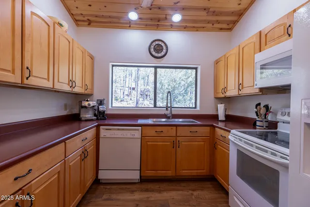 a kitchen with stainless steel appliances granite countertop a sink and cabinets with wooden floor