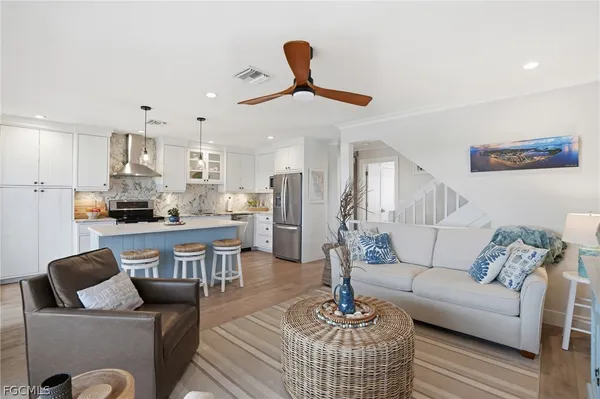 a living room with furniture kitchen view and a chandelier
