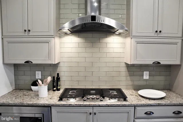 a kitchen with a stove and white cabinets
