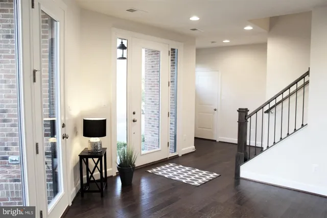 a view of a hallway with wooden floor and windows